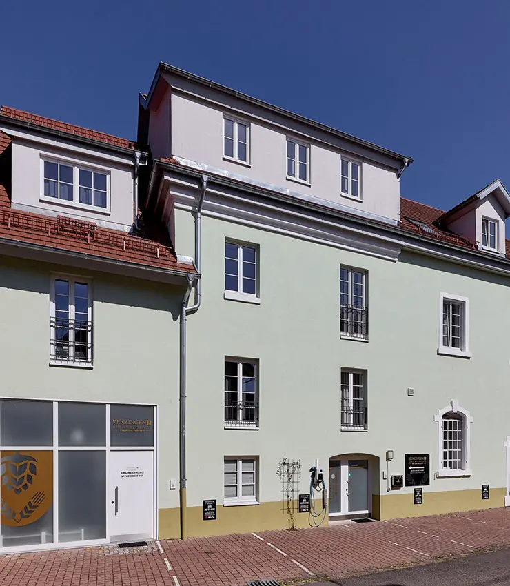 Historische hellgrüne Fassade der Kenzingen Appartements mit Eingang am Kirchplatz